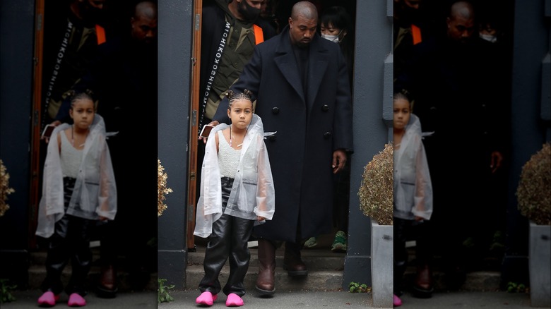 North West walks beside Kanye West