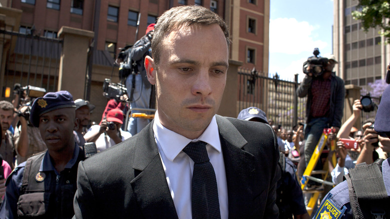 Oscar Pistorius surrounded by security and media