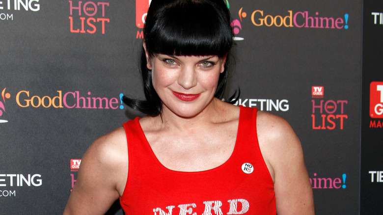 Pauley Perrette poses in a red tank top with the word 'nerd'