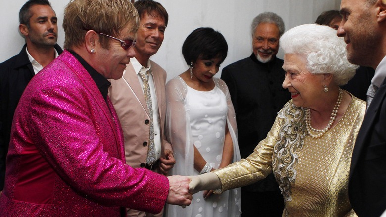 Elton John shakes hands with Queen Elizabeth