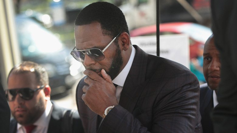 R. Kelly covers his mouth outside a courthouse