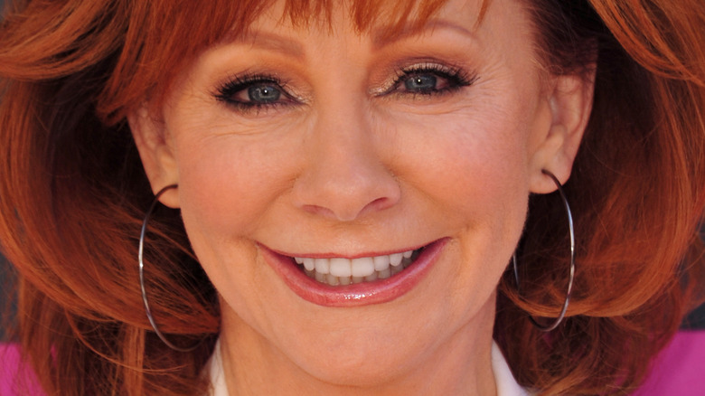 Reba McEntire smiles in hoop earrings