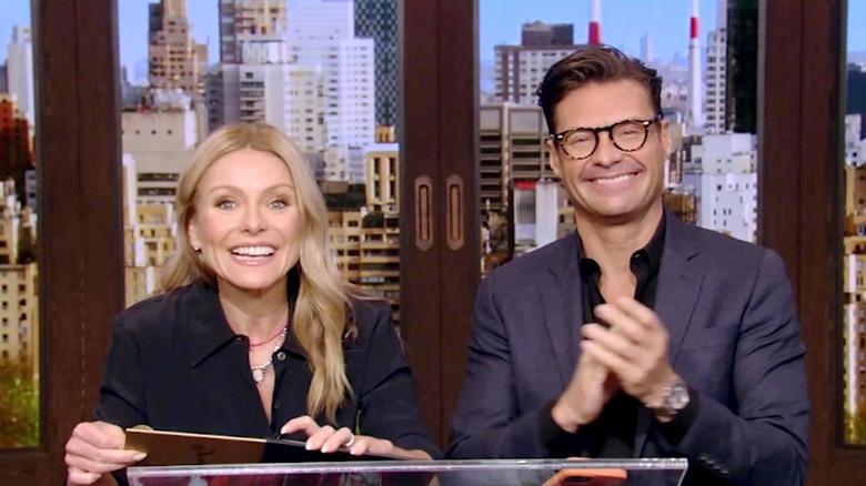 Kelly Ripa and Ryan Seacrest smiling on set