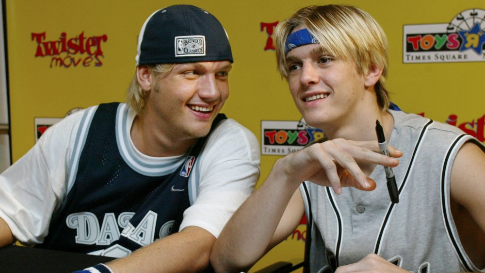 Nick Carter and Aaron Carter joking around while signing autographs 