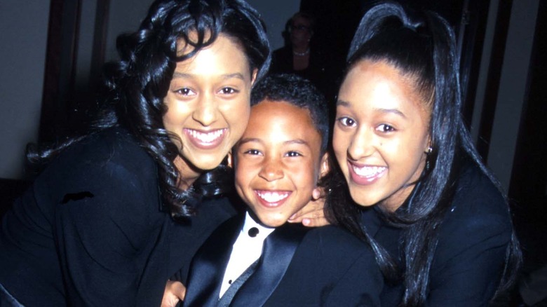 Young Tahj Mowry with sisters Tia and Tamera, all smiling