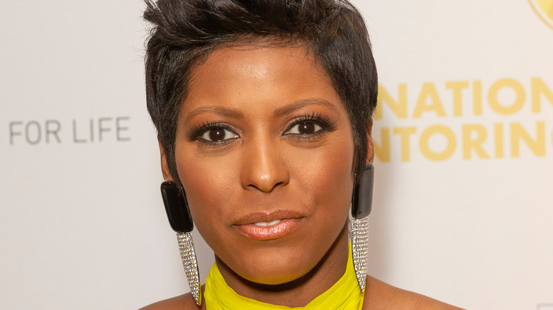 Tamron Hall wearing long diamond earrings, posing