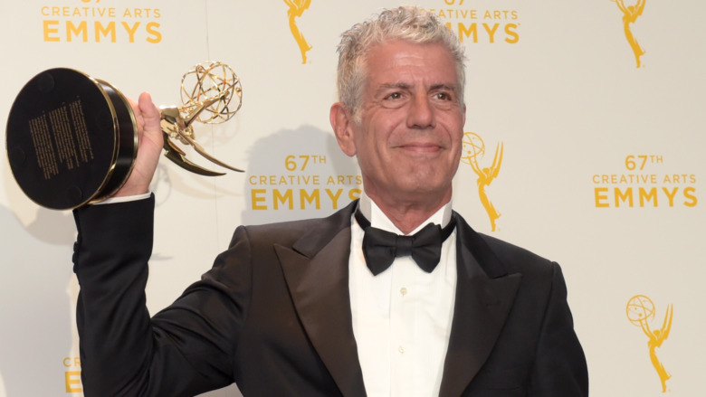 Anthony Bourdain holding an Emmy