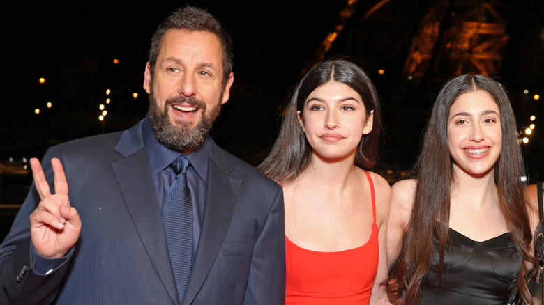 Adam Sandler posing with daughters Sadie and Sunny outdoors