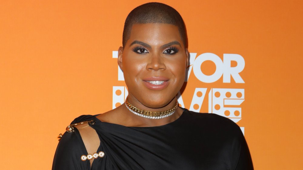 EJ Johnson in black outfit and gold and silver chokers