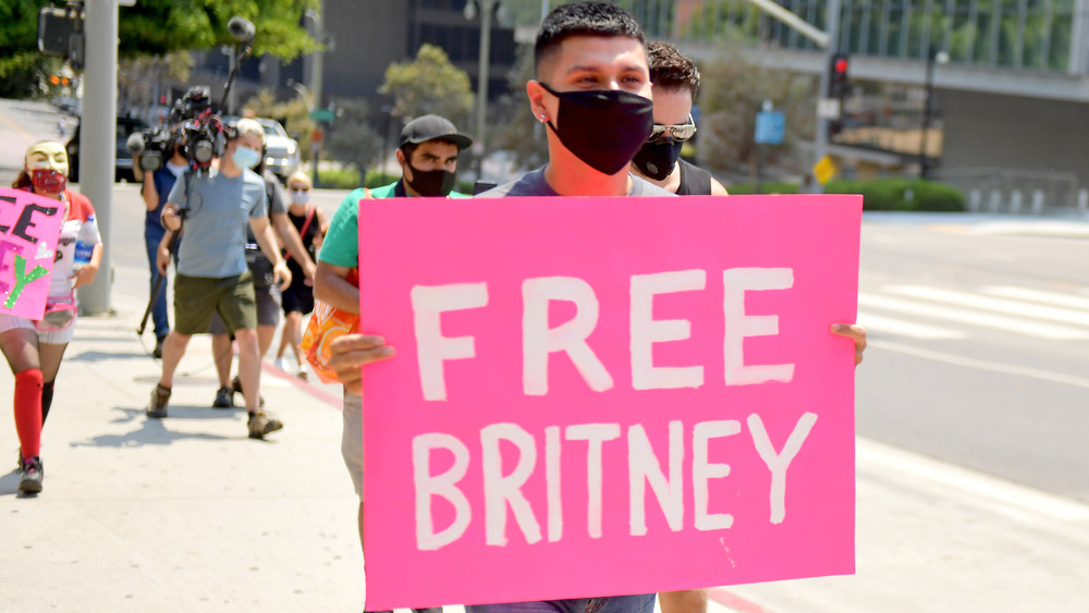 A man holding a sign that reads "Free Britney"