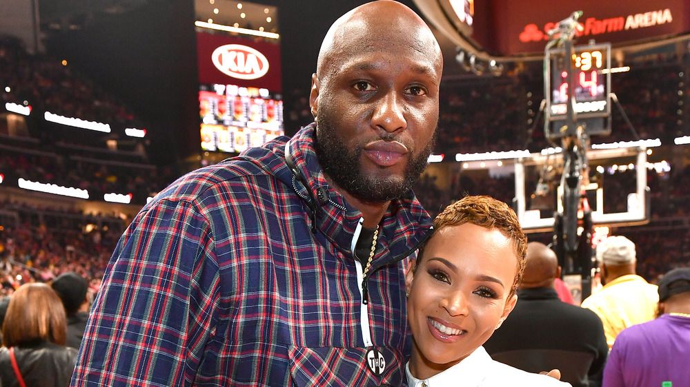 Lamar Odom and Sabrina Parr posing at game