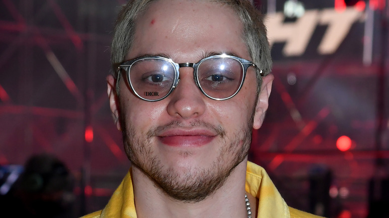 Pete Davidson wearing glasses with slight smile