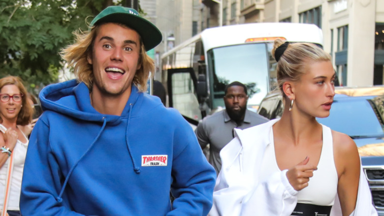 Justin Bieber making a funny face while walking outside with Hailey Baldwin