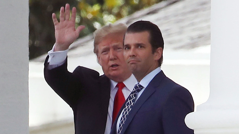 Donald Trump waving next to Donald Trump Jr.