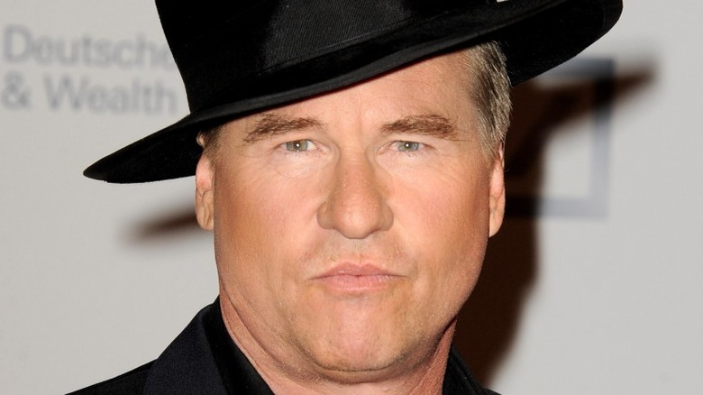 Val Kilmer wearing tilted black hat