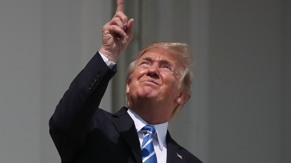 Donald Trump looking up during the solar eclipse