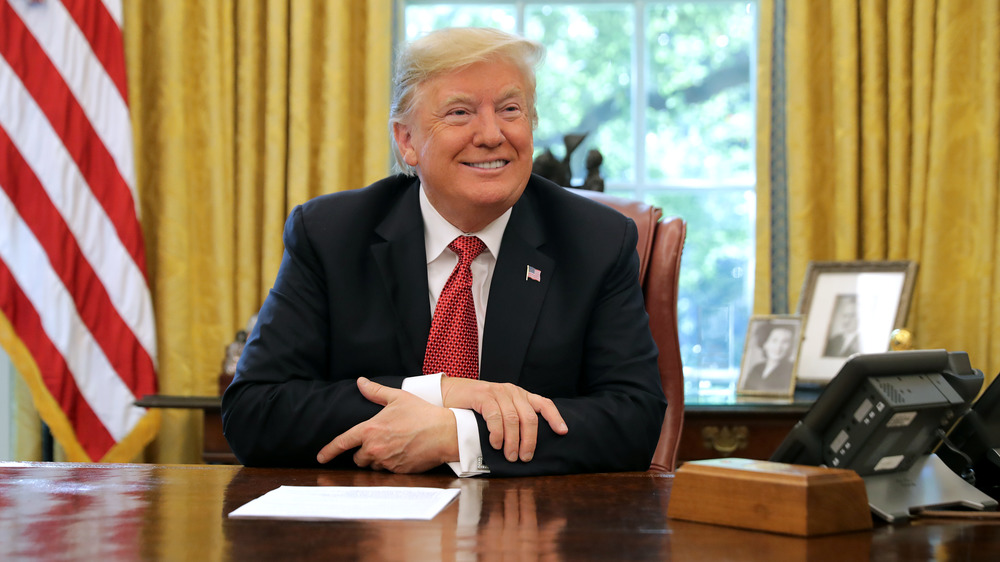 Donald Trump seated in the Oval Office