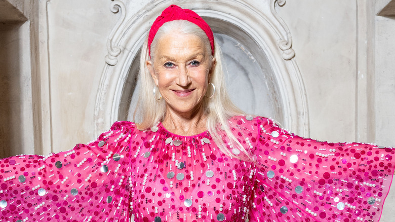 Helen Mirren smiling in a pink headband