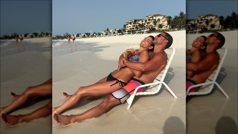 Angie Harmon sits on Greg Vaughan's lap at the beach