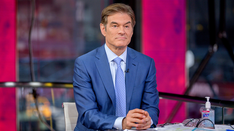 Dr. Oz in a blue suit at a table