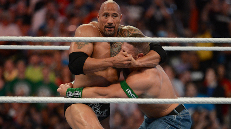 Dwayne Johnson headlocks John Cena