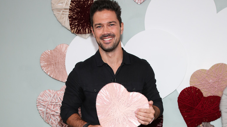 Ryan Paevey holds a decorated paper heart 