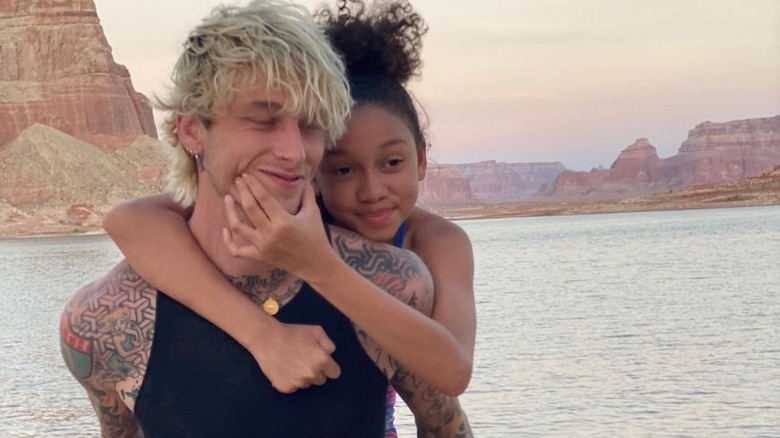 Machine Gun Kelly poses with Casie on his back