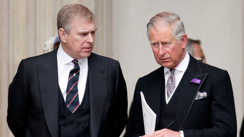 Prince Andrew and Prince Charles looking upset