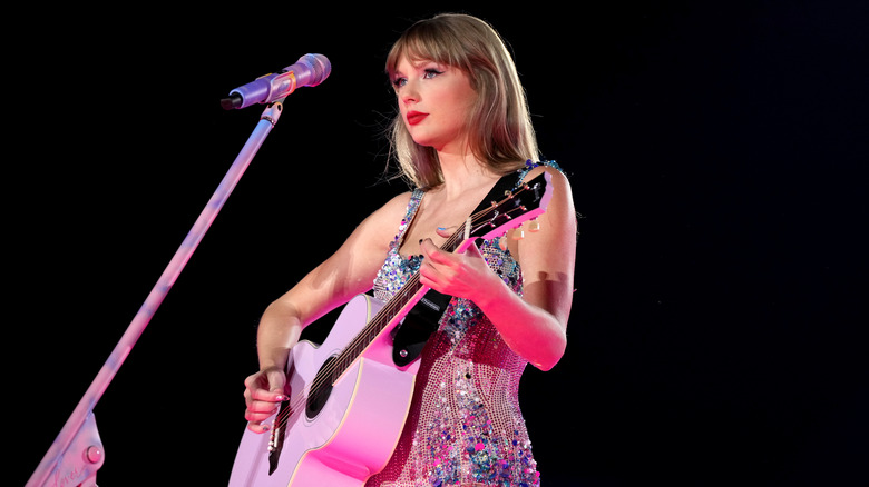 Taylor Swift playing pink guitar