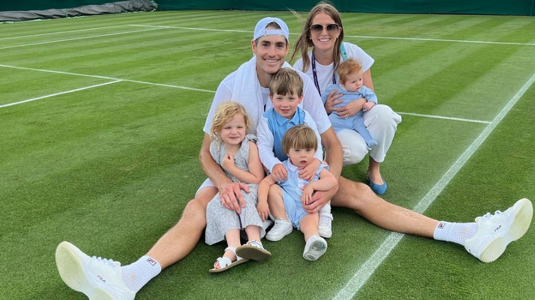 The Isner family smiles on a tennis court