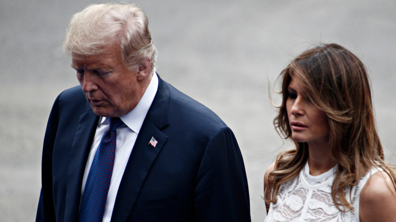 Donald Trump and Melania Trump walking outside in wind