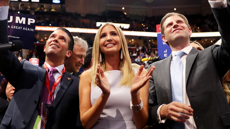 Donald Jr., Ivanka, and Eric Trump smiling and applauding