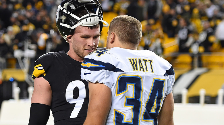 Derek and T.J. Watt talking on the field