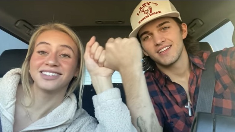 Lilyan Cole and Jaden Hamilton holding hands in car