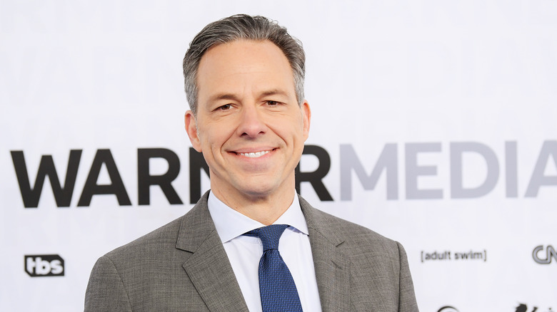 Jake Tapper poses in a suit and tie