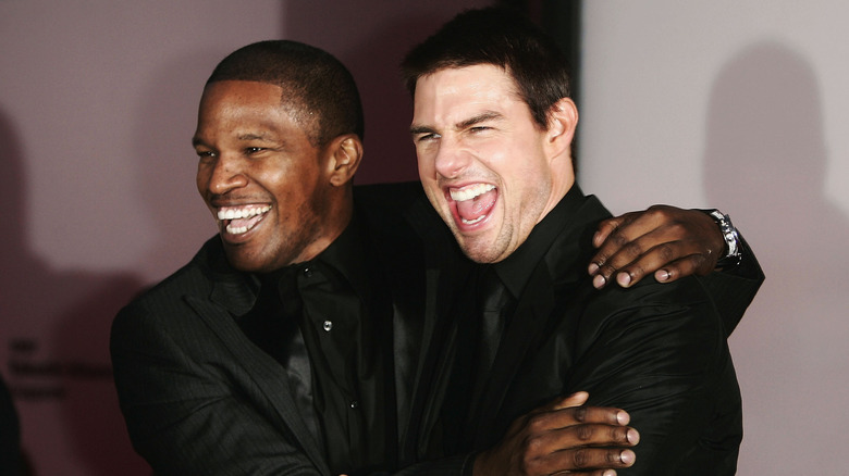 Jamie Foxx and Tom Cruise hugging and grinning