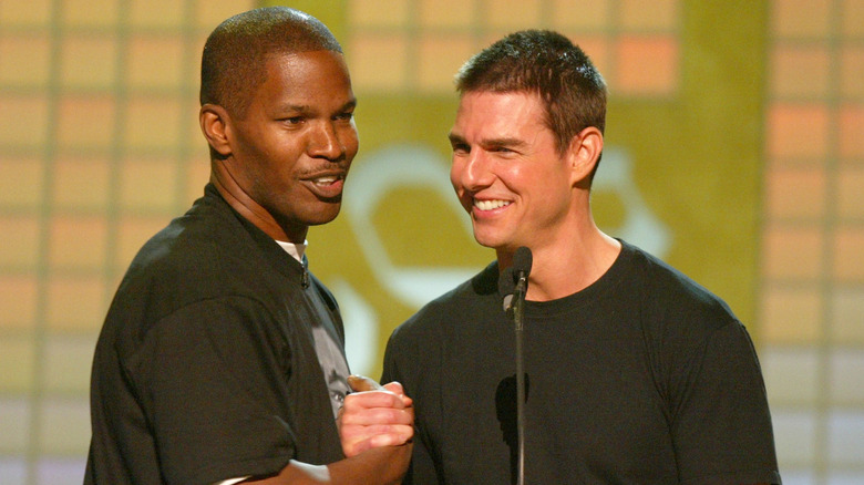 Jamie Foxx and Tom Cruise clutching hands