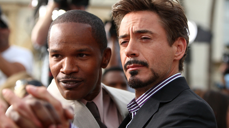 Jamie Foxx clasping hands with Robert Downey Jr.