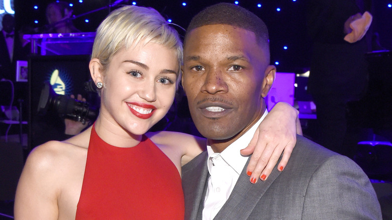 Miley Cyrus with arm around Jamie Foxx