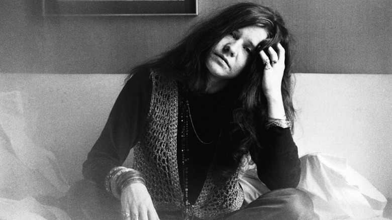 Janis Joplin posing with her head cocked and a sad expression