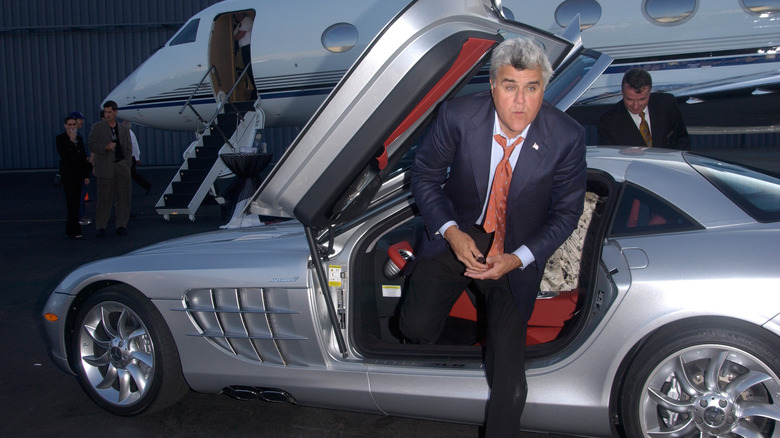 Jay Leno stepping out of a luxury car 