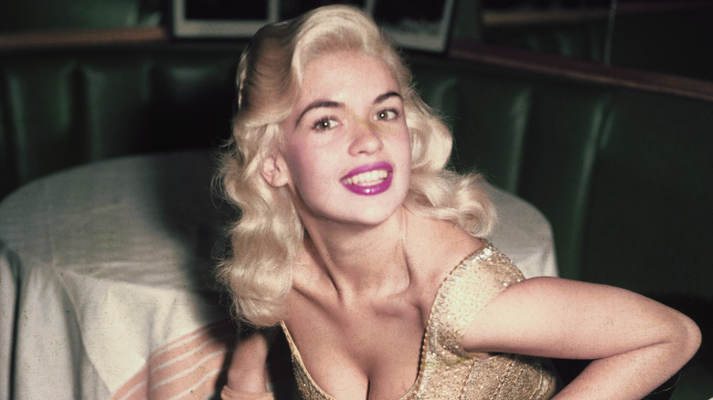 Jayne Mansfield posing at a table.