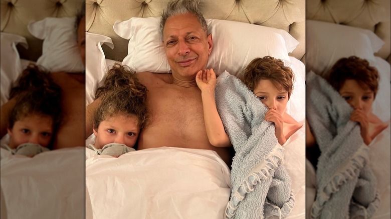 Jeff Goldblum smiling in bed with kids