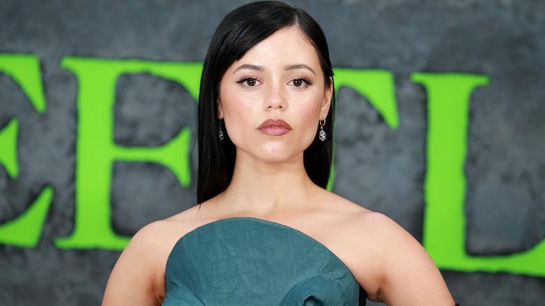 Jenna Ortega wearing a green gown with an elevated top and sleek black hair