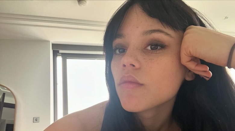 Jenna Ortega wearing a black tank top and hair tie on her wrist