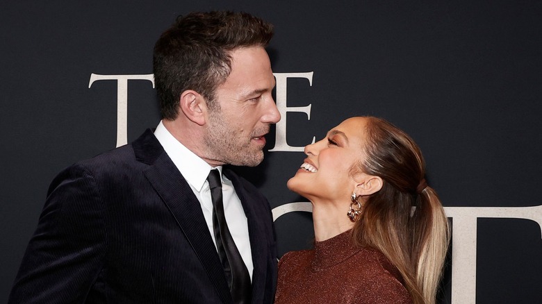 Ben Affleck and Jennifer Lopez smiling on the red carpet 