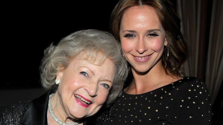 Betty White with her head on Jennifer Love Hewitt's shoulder