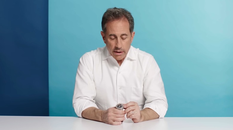 Jerry Seinfeld stares at his Breitling watch