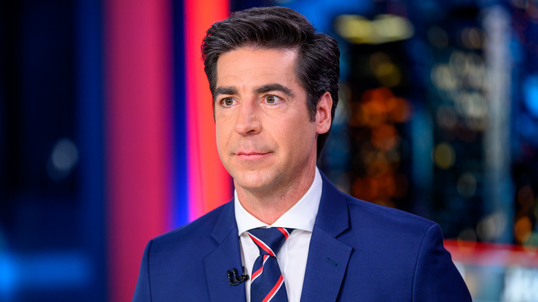 Jesse Watters in a blue suit and striped tie