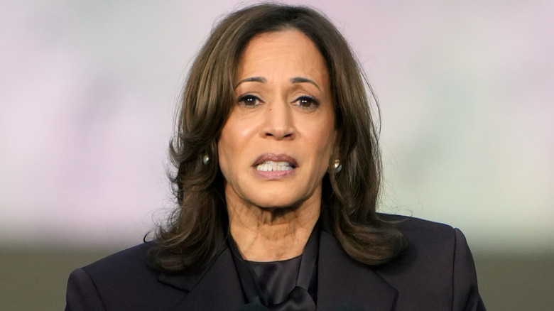 Kamala Harris wearing a black suit with uneasy expression